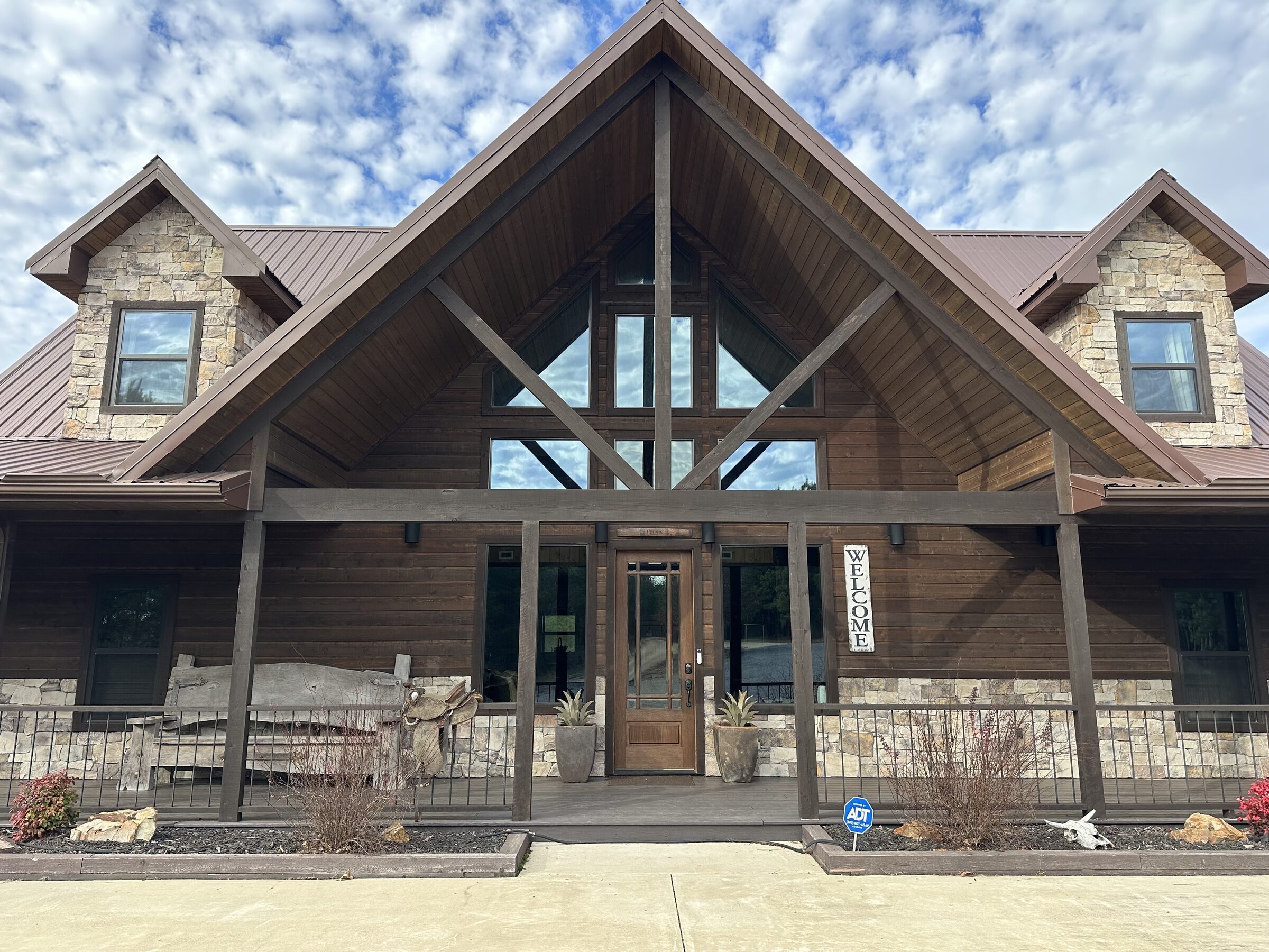 Timber-and-stone entrance of Mack Mountain Lodge with a soaring glass gable
