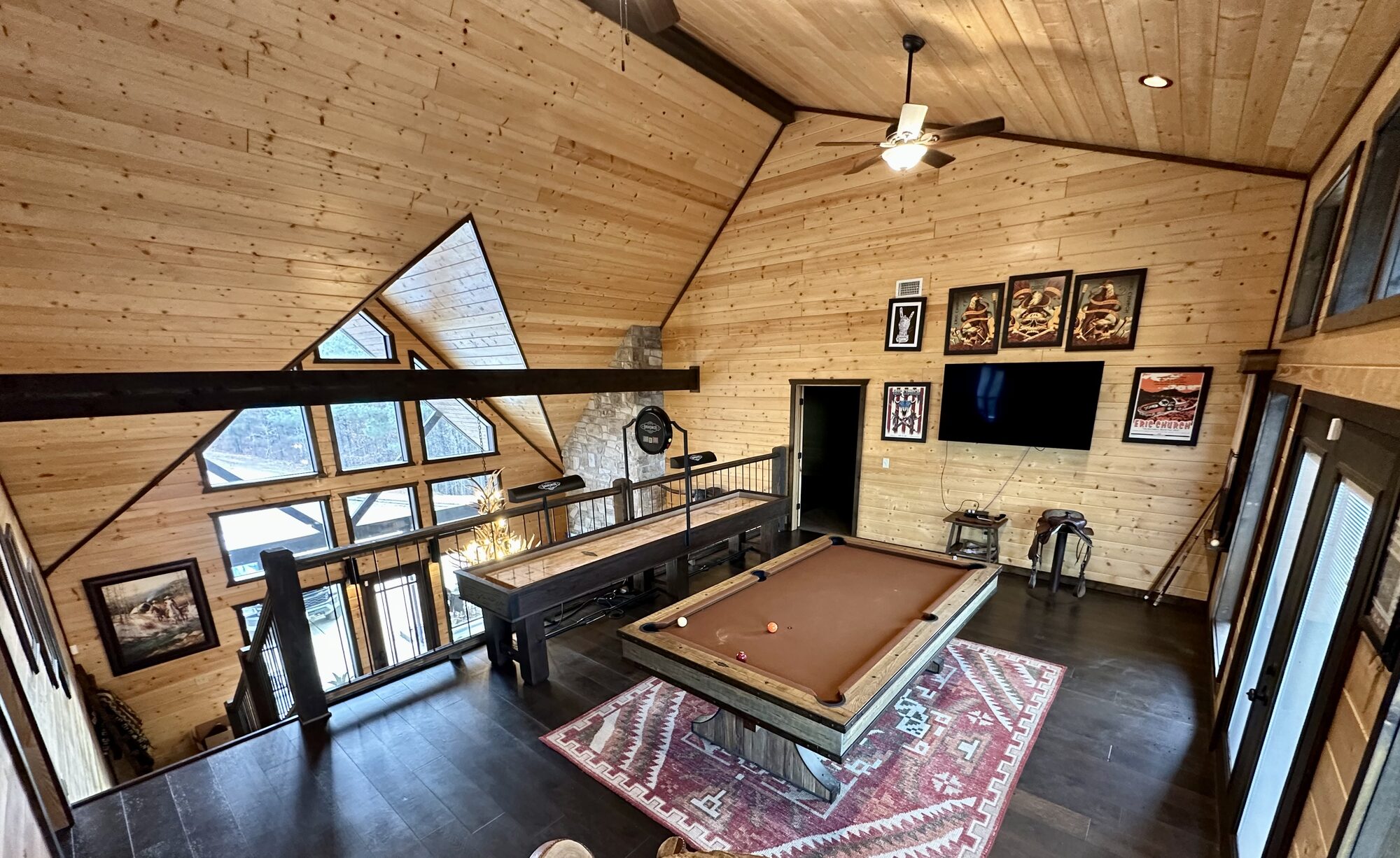 Game-room loft with pool table and shuffleboard under an A-frame window