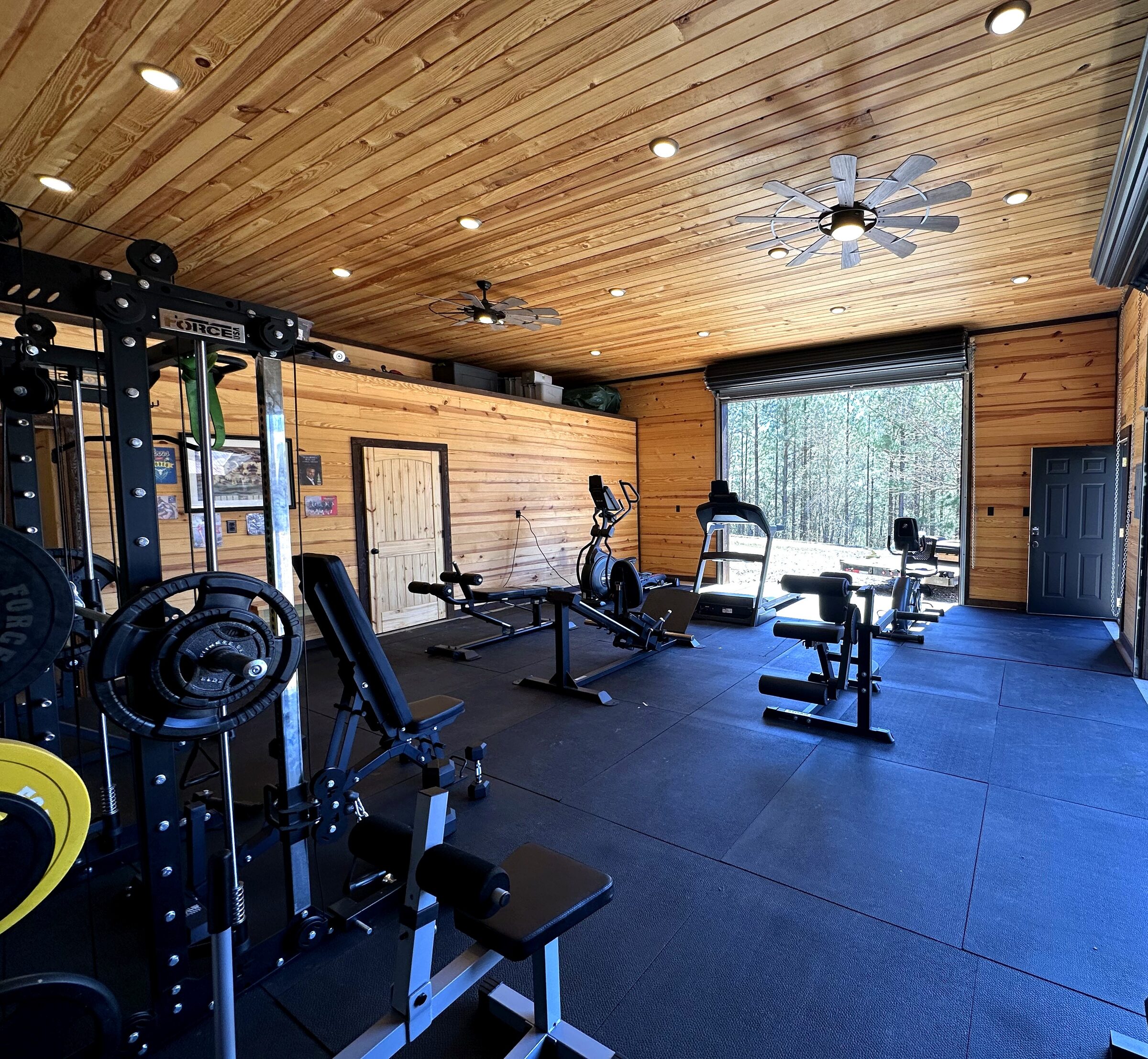 Fully equipped home gym opening to the pines